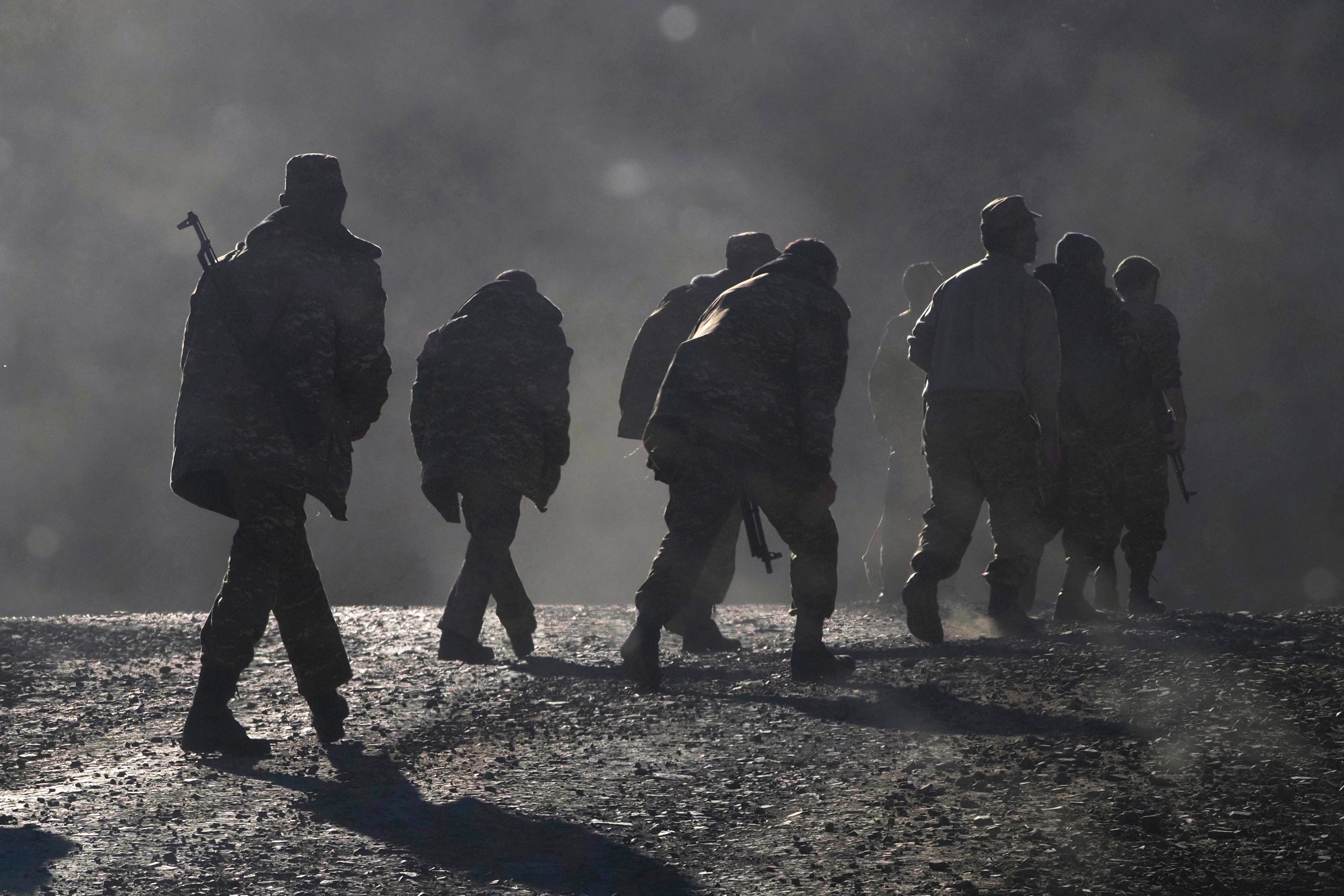 Ethnic Armenian soldiers walk along the road near the border between Nagorno-Karabakh and Armenia, Sunday, Nov. 8, 2020.