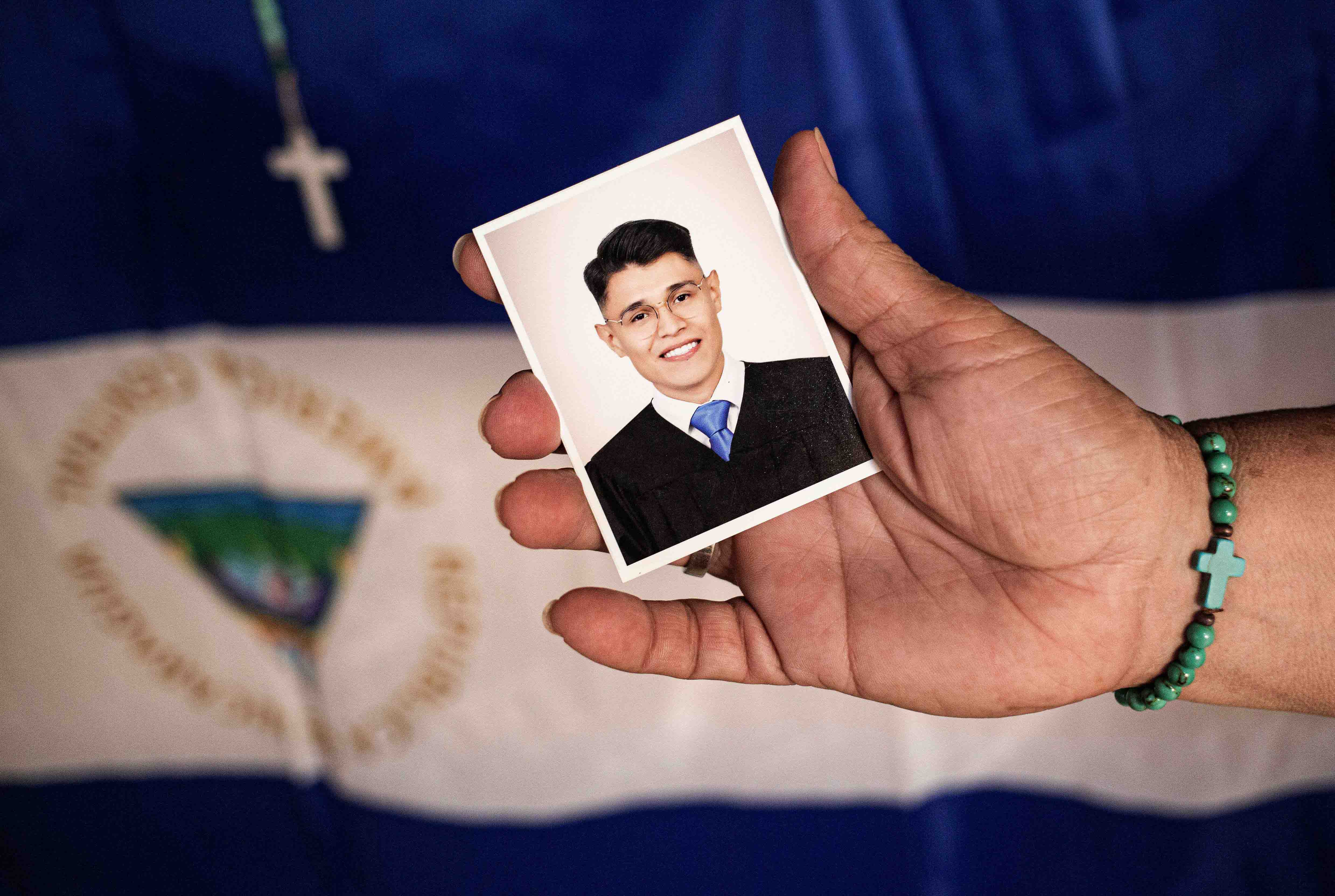 Lesbia Alfaro, madre del líder estudiantil Lesther Alemán, exiliado luego de participar en las protestas contra el gobierno del presidente nicaragüense Daniel Ortega en 2018, sostiene un retrato de su hijo durante una entrevista con AFP en Managua, el 14 de septiembre de 2021. 