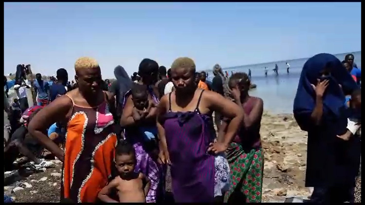 Des femmes et des enfants expulsés par les autorités tunisiennes à la frontière libyenne, photographiés près du rivage, le 6 juillet 2023. @ 2023 Privé