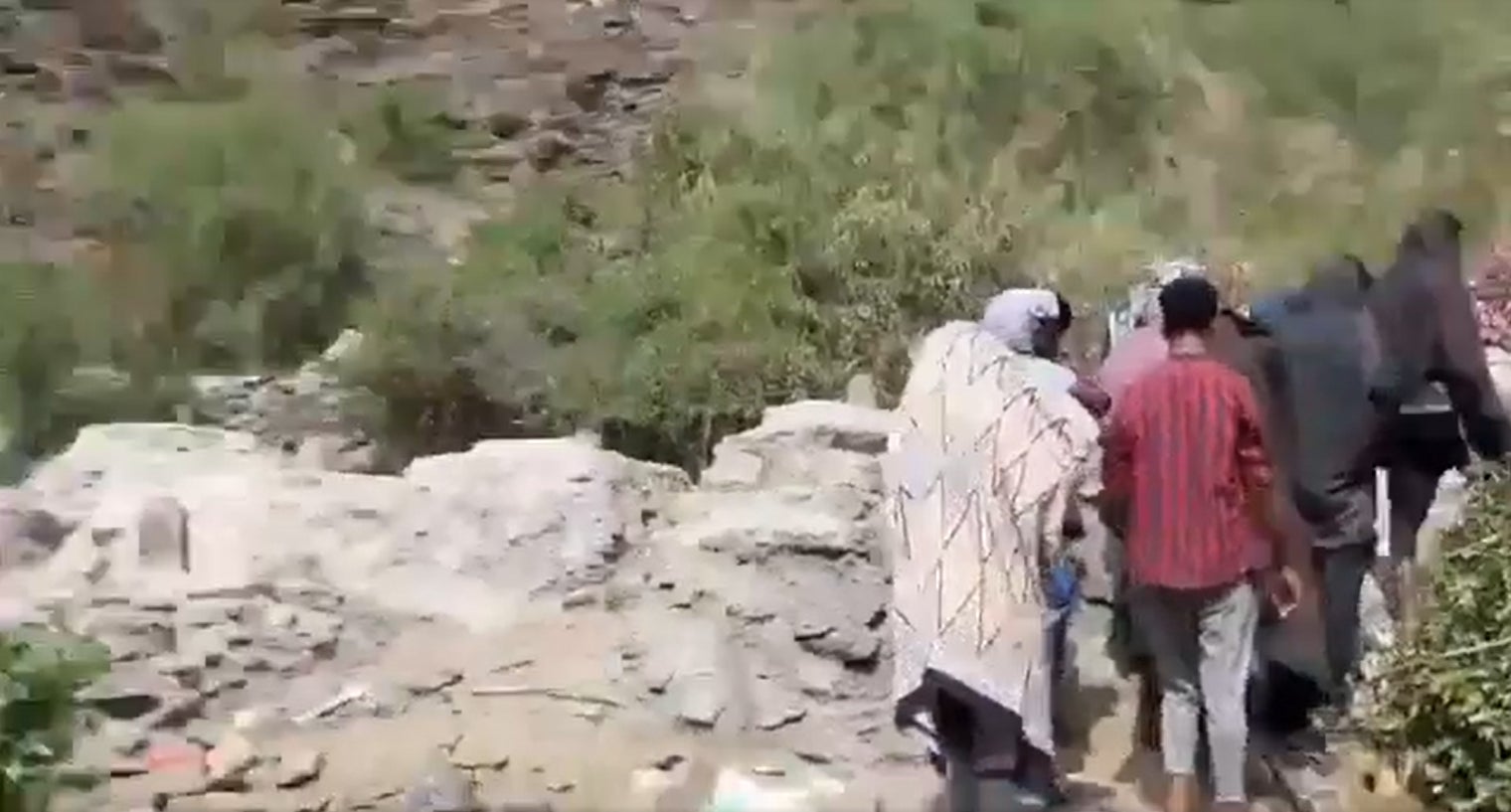 A video published on May 16, 2022 and geolocated by Human Rights Watch shows migrants walking past cement graves during a burial ceremony at the largest burial site in Al Raqw.