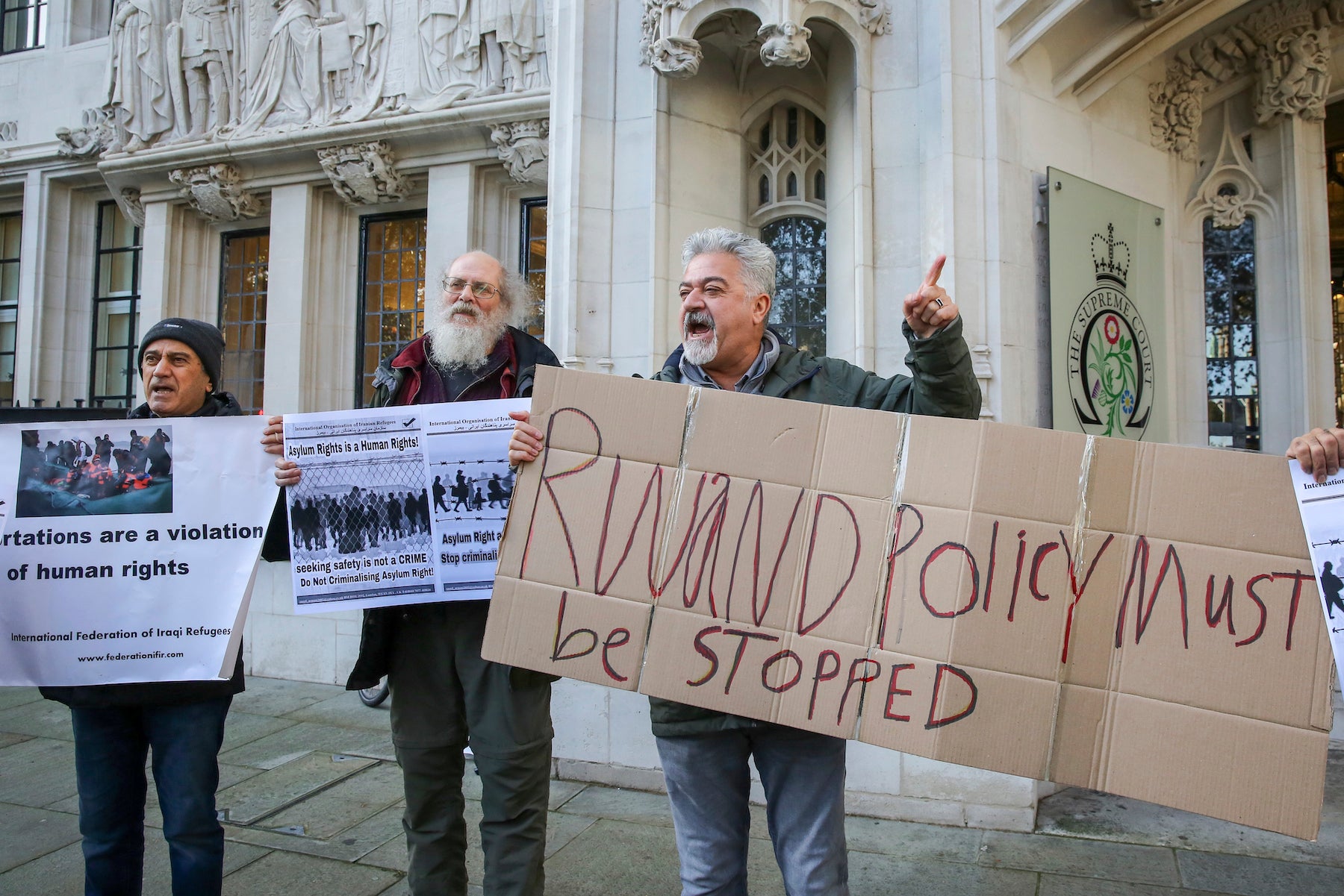 Protesters hold placards outside the UK’s Supreme Court as it rules that the UK Government's Rwanda asylum plan is unlawful, London, United Kingdom, November 15, 2023.