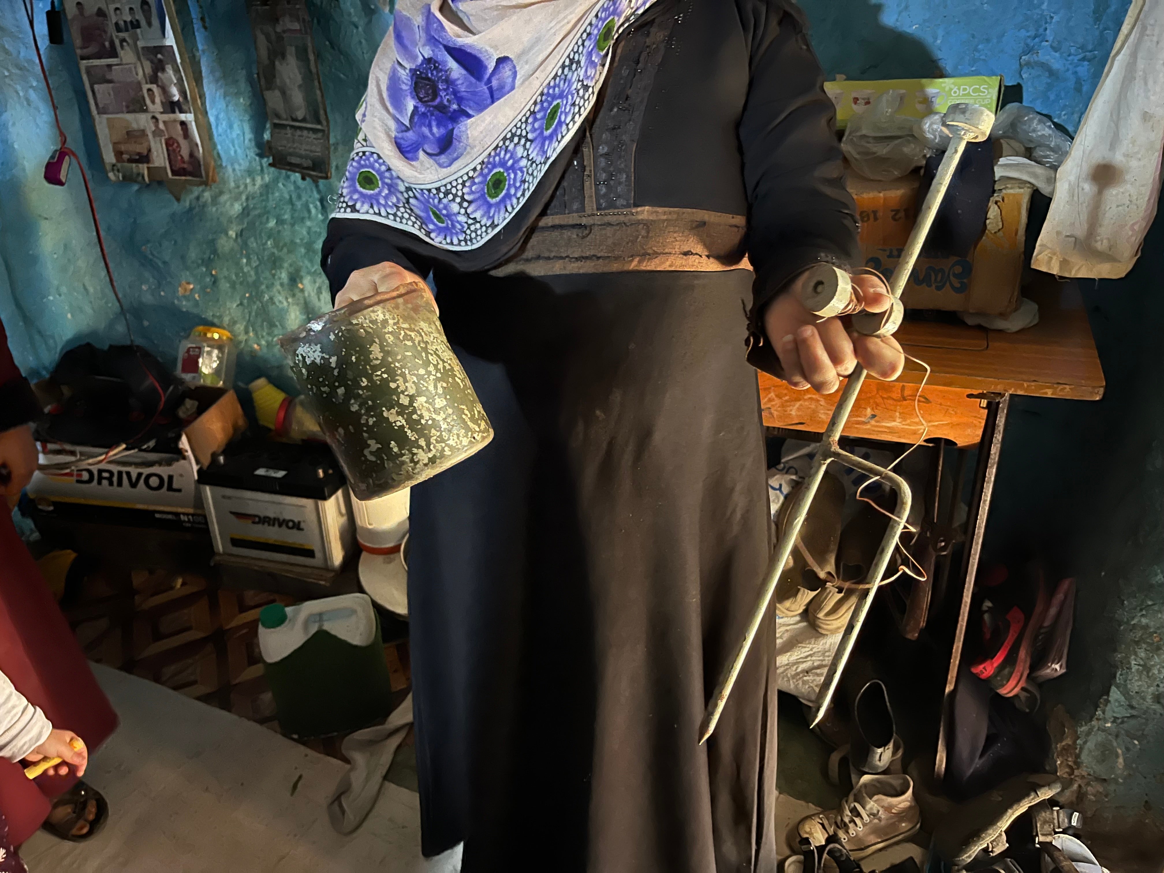 امرأة تحمل مخلفات لغم أرضي قتل والدها في الشقب، اليمن في 27 أبريل/نيسان 2024. 