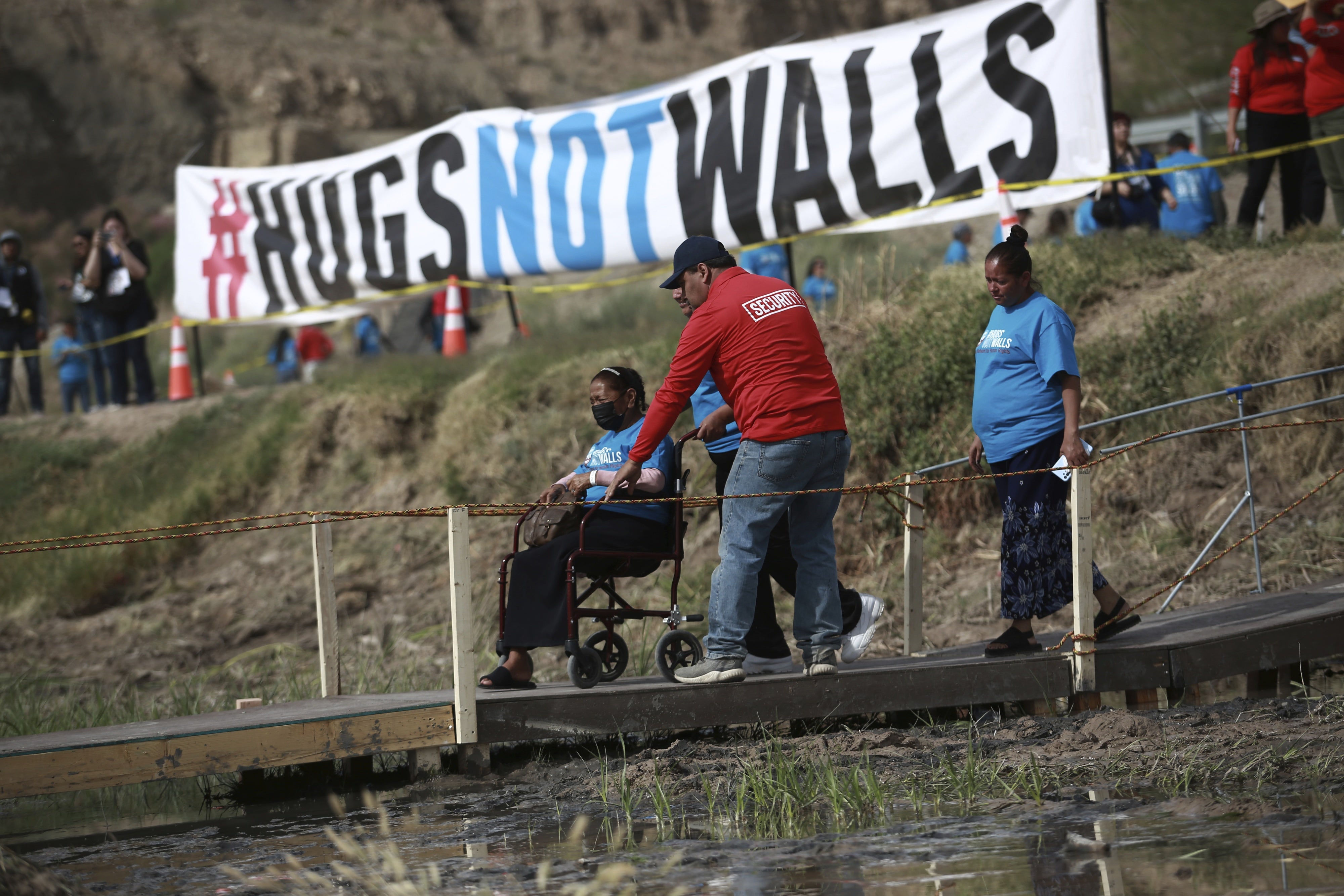 People living in Mexico cross a temporary bridge to meet with relatives living in the U.S., during the 10th annual "Hugs not Walls" event on a stretch of the Rio Grande, in Ciudad Juarez, Mexico, Saturday, May 6, 2023. The brief family reunions are part of a campaign sponsored by the Border Network for Human Rights, an immigration rights group. © 2023 AP Photo/Christian Chavez