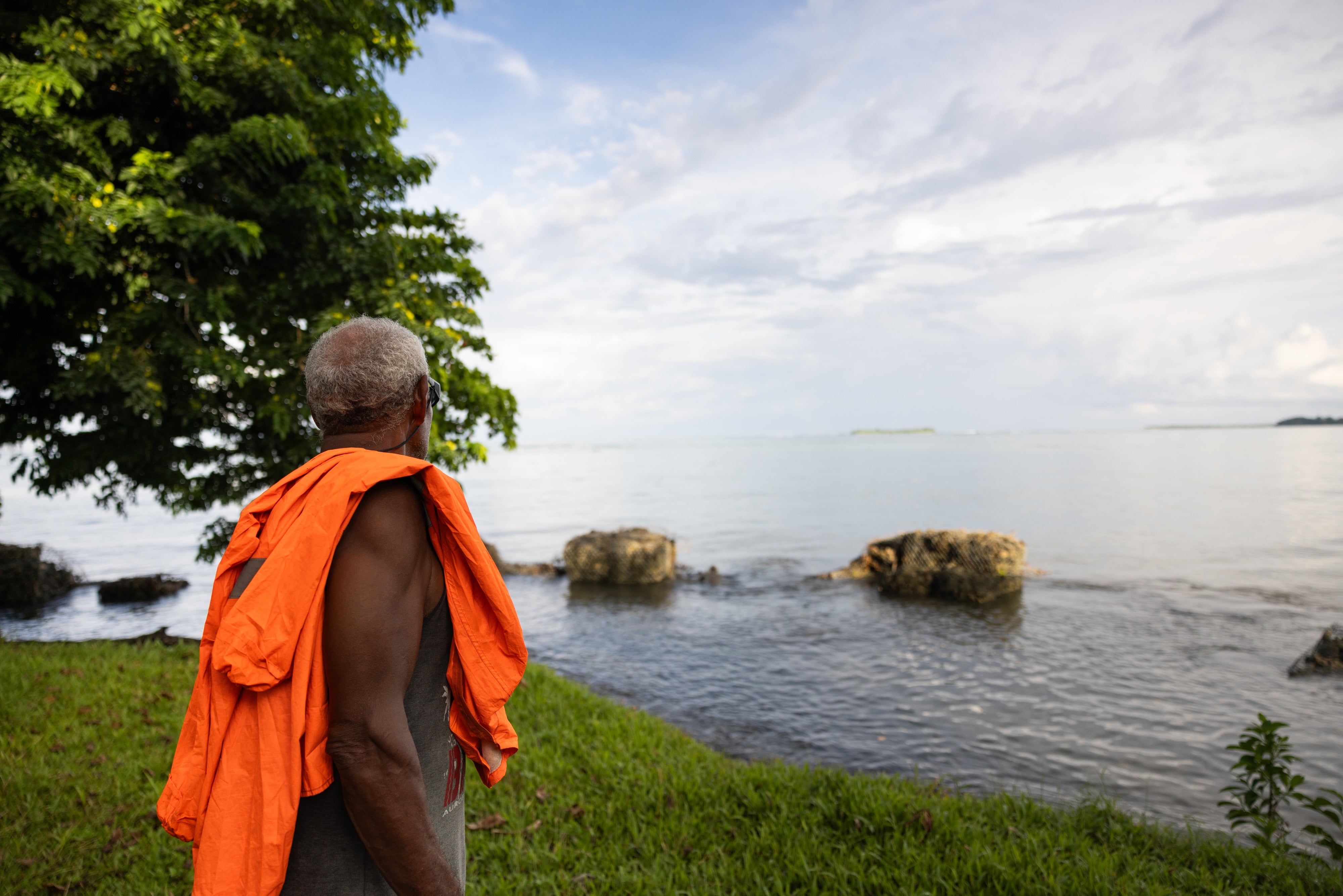 Un chef de communauté regarde la digue qui s'est récemment effondrée et ne protège plus complètement le village de Walande, dans la province de Malaita, aux Îles Salomon.