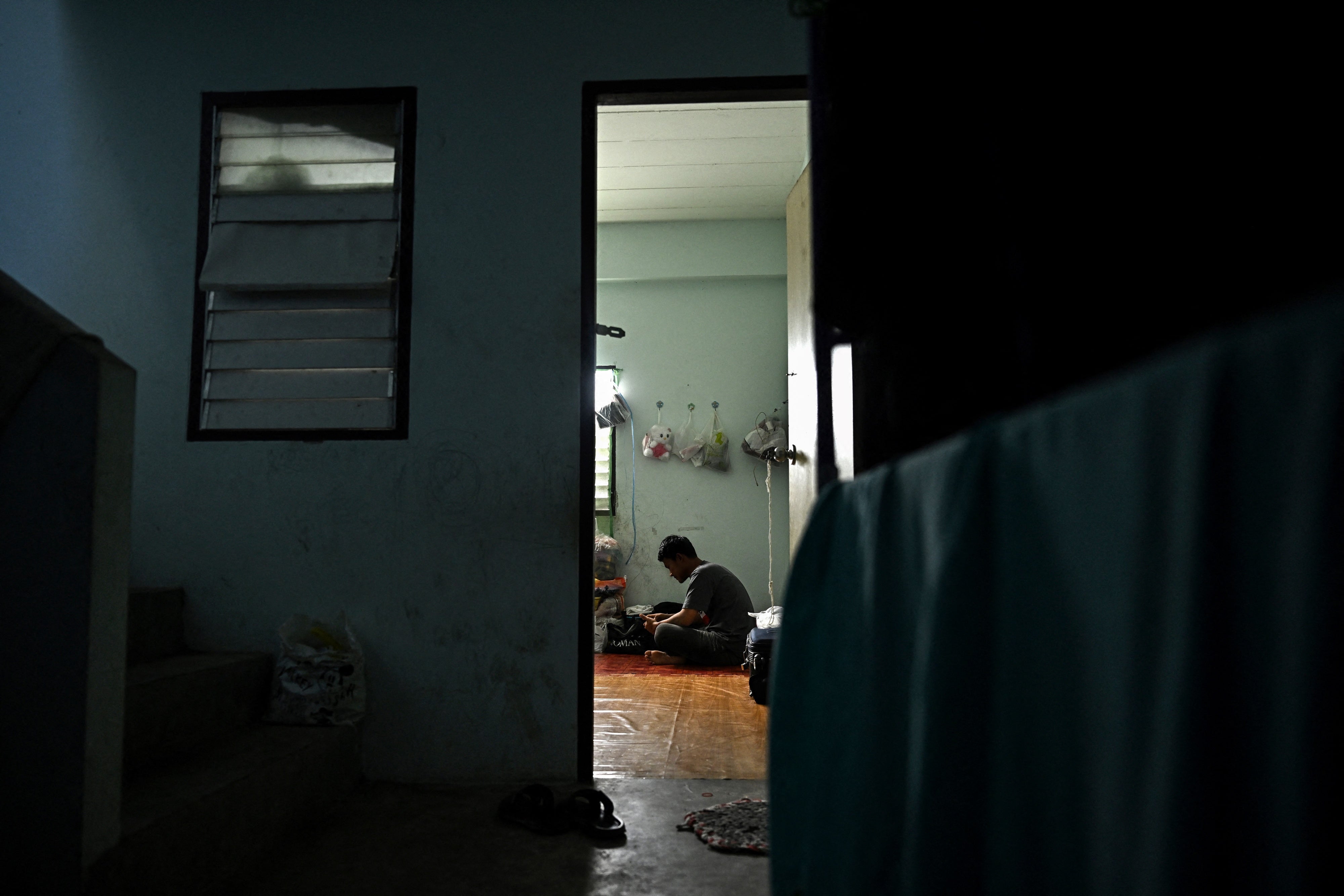 Un travailleur migrant originaire du Myanmar était assis dans l’appartement où il réside, dans la province de Samut Sakhon, en Thaïlande, le 26 janvier 2025. 