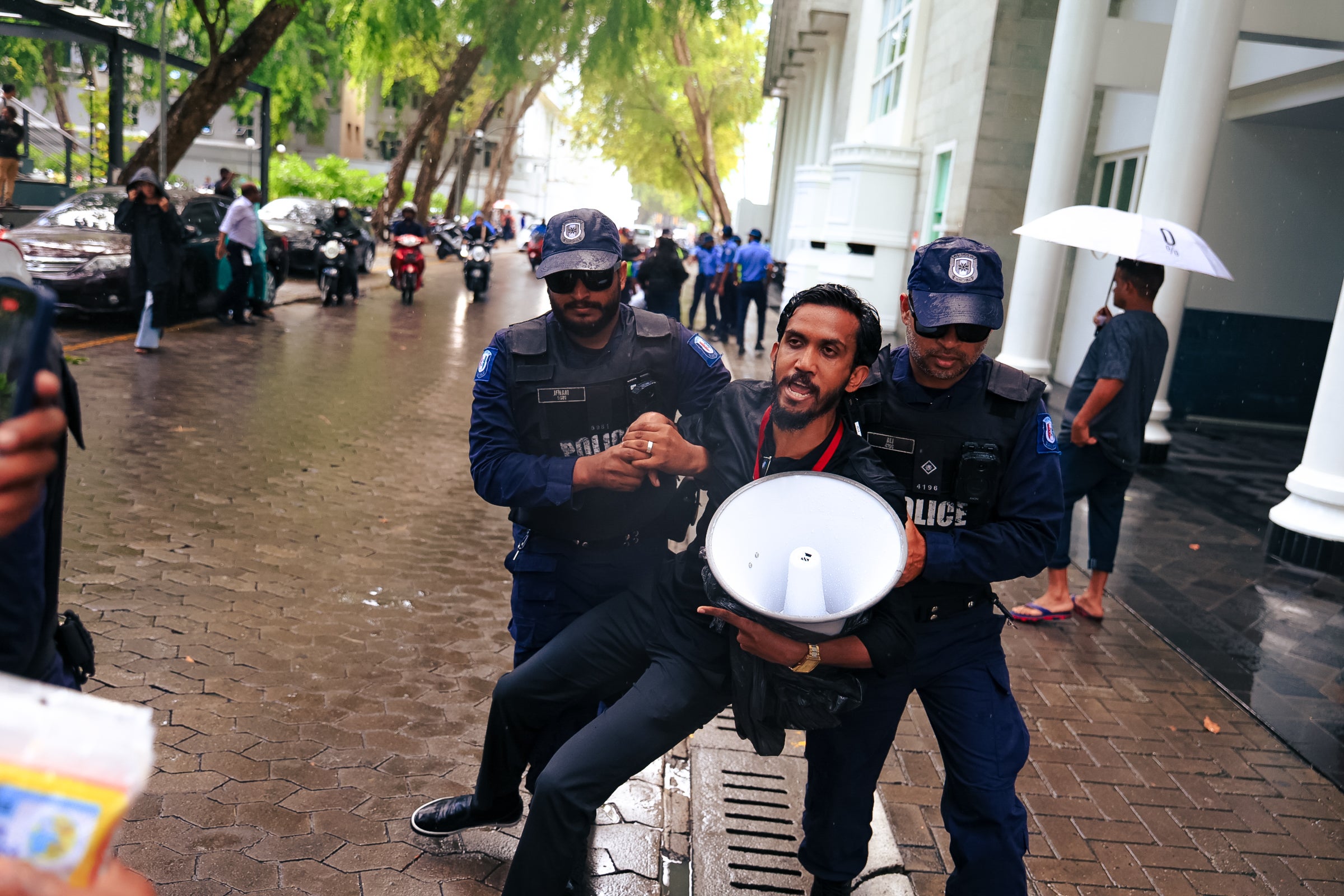 Maldives police detain a journalist during a protest against the Maldives Media and Broadcasting Regulation Bill outside government offices in the capital, Malé, on August 27, 2025.