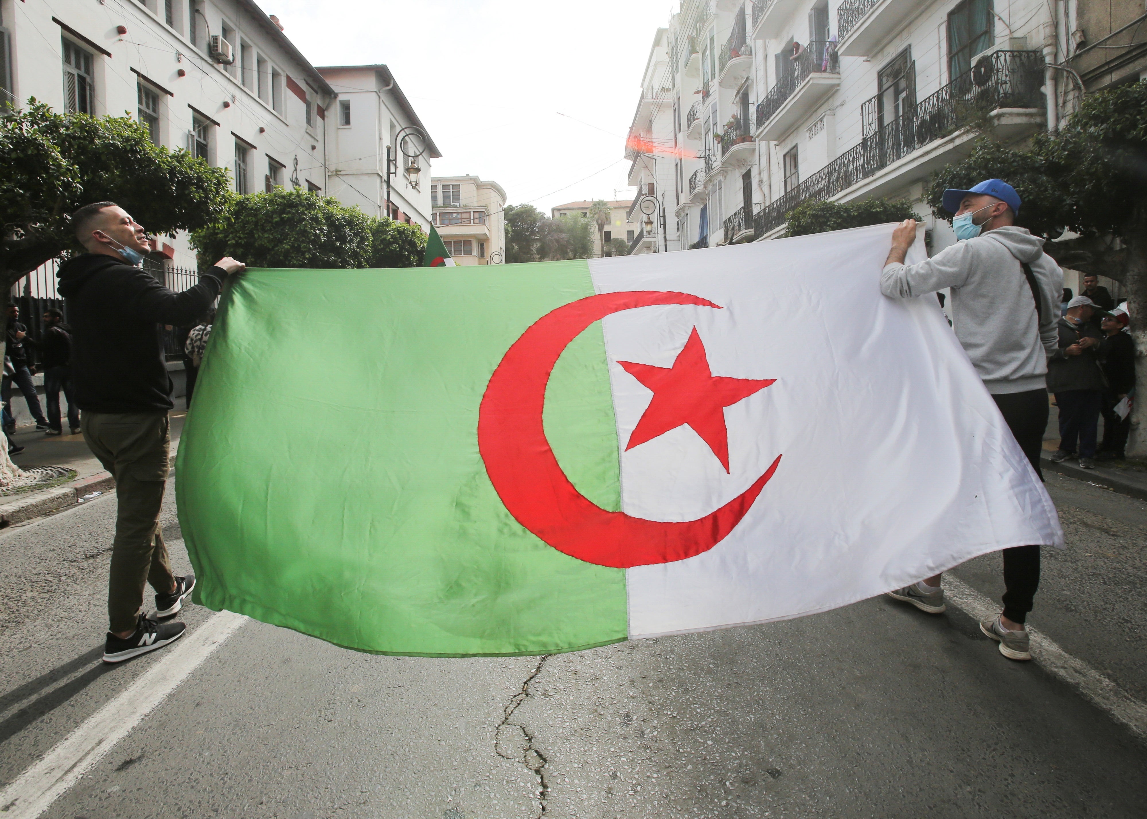 Demonstrators carry an Algerian flag in Algiers, Algeria, April 2, 2021.