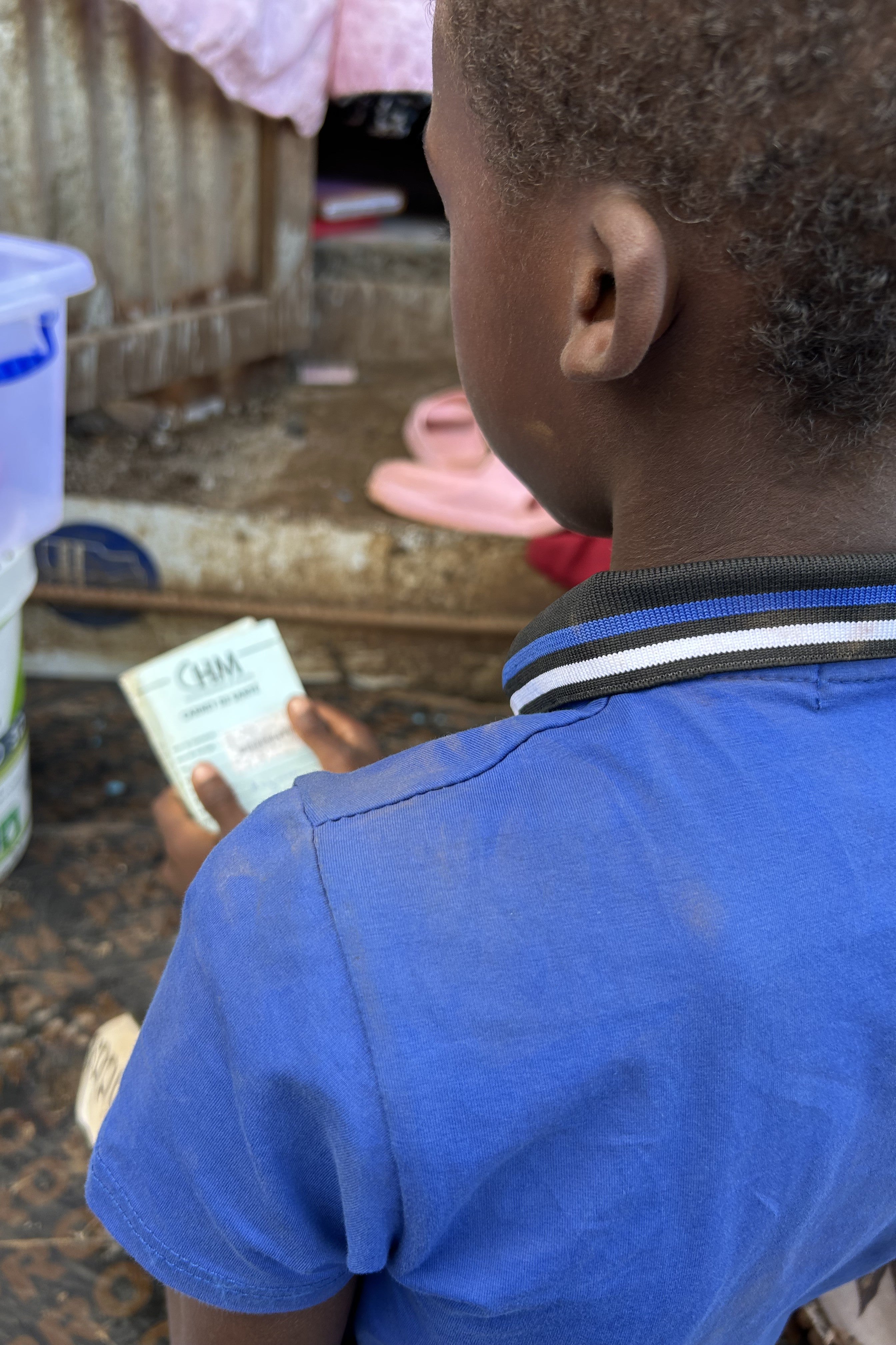 A boy holds a vaccination card