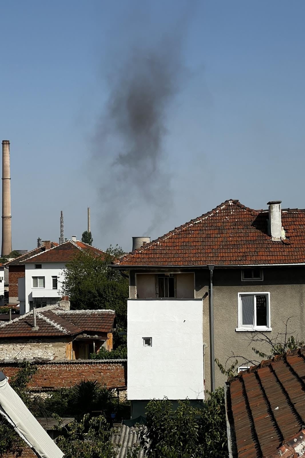 Smoke billowing from towers at a coal plant near a residential neighborhood