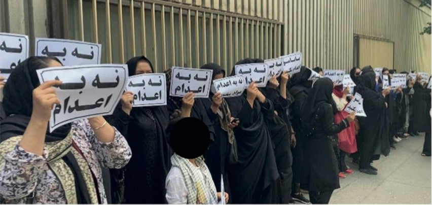 Les proches de condamnés à mort se rassemblent devant le palais de justice à Téhéran, en Iran, le 24 mai 2023, brandissant des pancartes sur lesquelles on peut lire « Non aux exécutions ». 