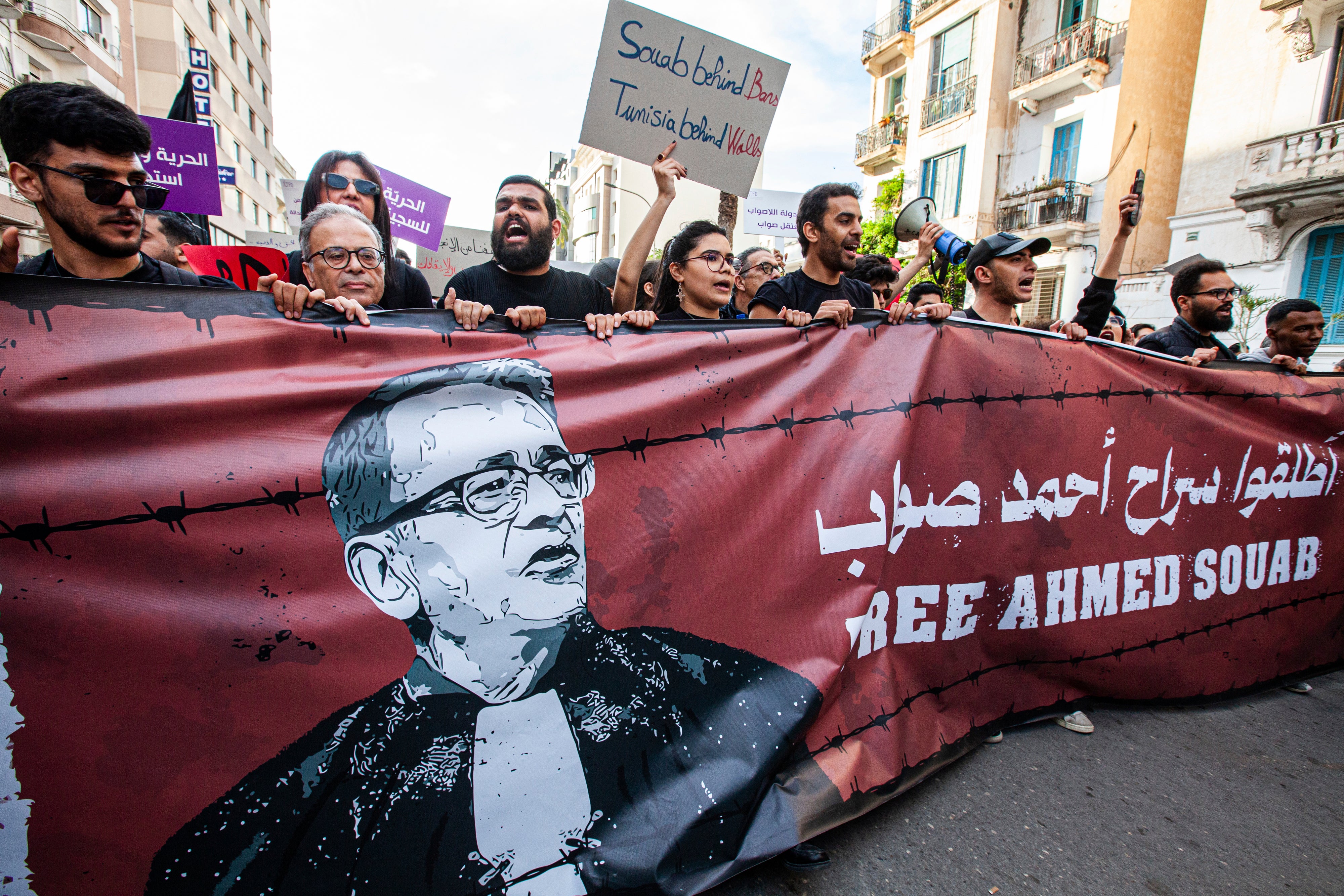 Des manifestants tenaient une banderole exprimant leur soutien à l'avocat et défenseur des droits humains Ahmed Souab, à Tunis, le 25 avril 2025 ; ils appelaient à sa libération a la suite de son arrestation le 21 avril, sur la base d’accusations liées au terrorisme. 