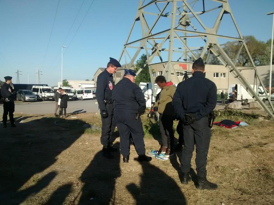 Después de interrumpir una distribución nocturna de alimentos y ropa, tres oficiales interrogaron a un menor que se había detenido para cambiarse de zapatos antes de regresar a la zona boscosa donde él y otros migrantes pasan la noche, mayo de 2017. 