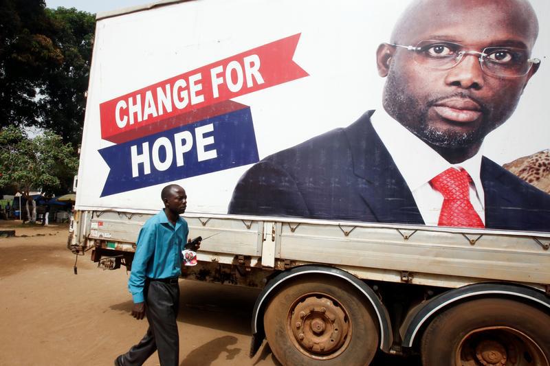 Un homme passe devant une affiche avec une photo géante de George Weah à Monrovia, au Liberia, le 27 décembre 2017, au lendemain de la victoire de Weah à l’élection présidentielle dans ce pays.  © 2017 Reuters