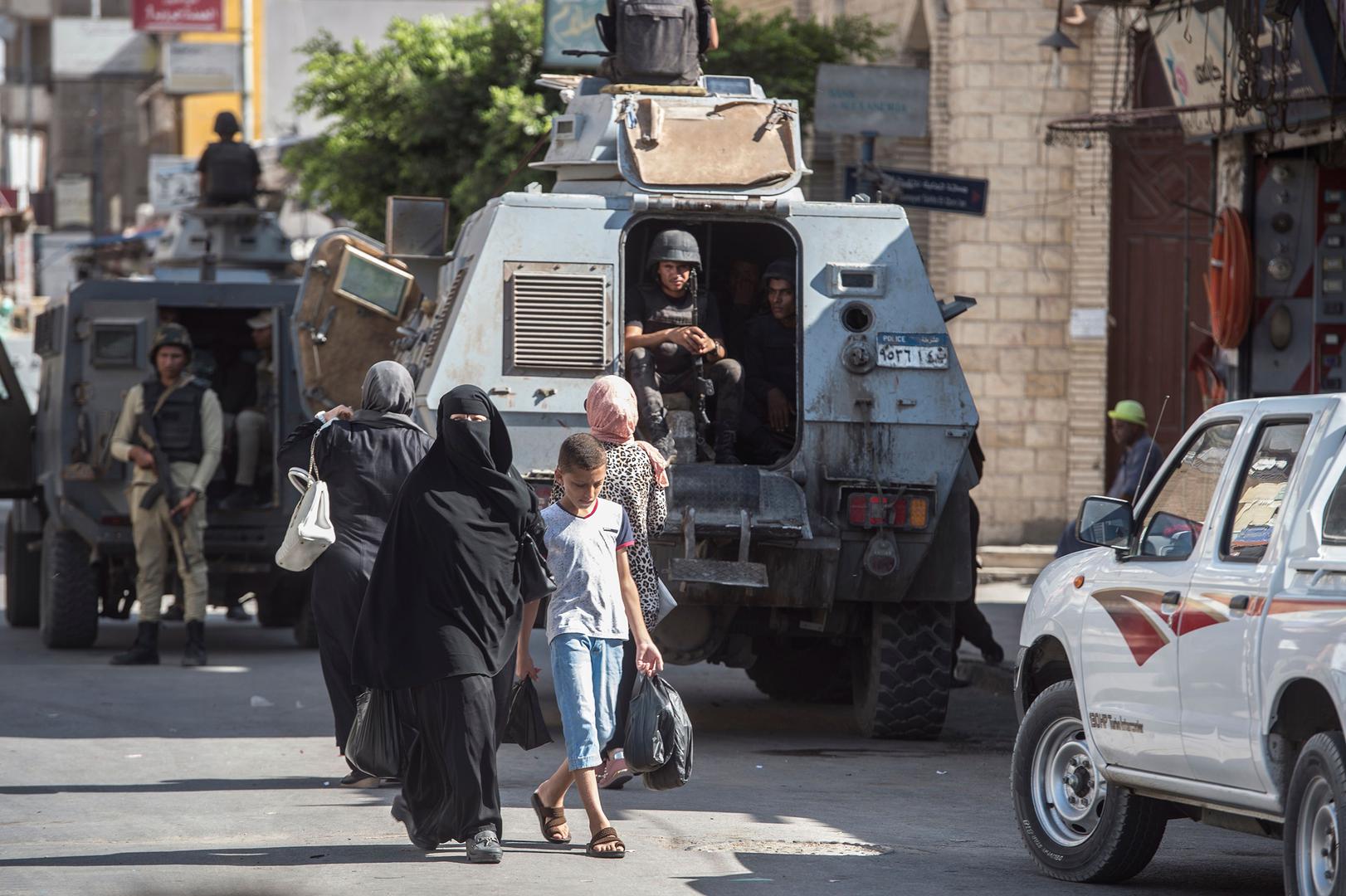 A picture taken on July 26, 2018 shows Egyptian policemen stand guarding a street in the North Sinai provincial capital of El-Arish. With fruit and vegetables aplenty in the markets, public transport back on the roads and universities reopened, life is re