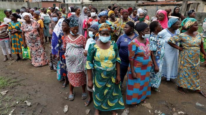 A group of women wait for food relief distribution
