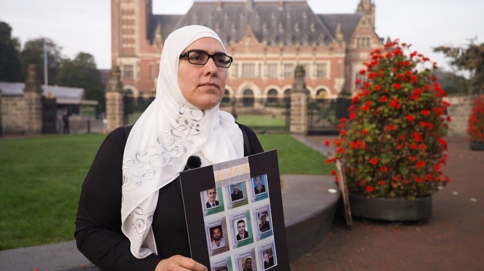 Bayan Rehan holding photos of her brother and friends who are detained in Syria at the International Court of Justice in The Hague, Netherlands, on October 10, 2023. 