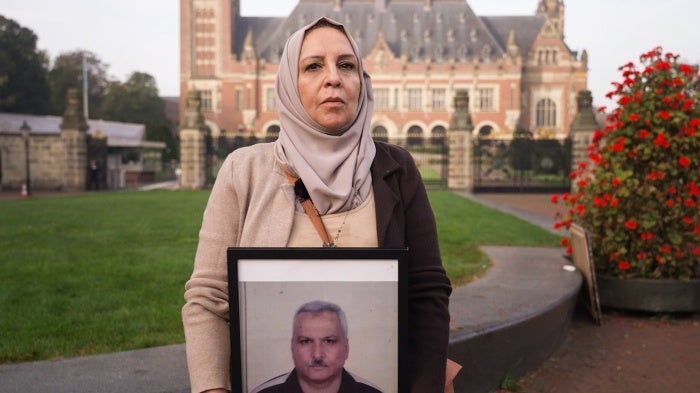 Samar Allouni holding a photo of her husband who was detained in Syria in 2015 at the International Court of Justice in The Hague, Netherlands, on October 10, 2023.