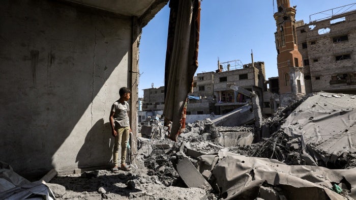 A boy stands amid the ruins of a collapsed building following Israeli bombardment in the Bureij camp for Palestinian refugees in the central Gaza Strip, May 23, 2025.