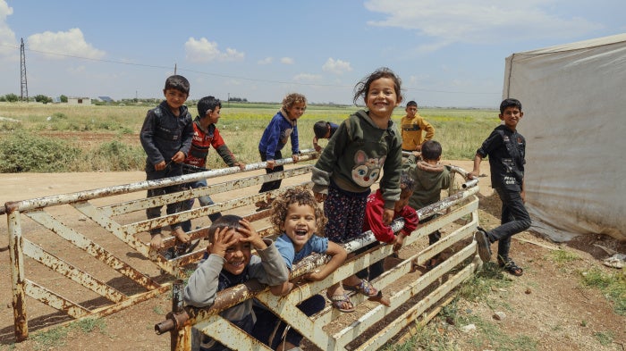 Displaced Syrian children laugh and play among temporary tents set up after the fall of the Bashar al-Assad government near Idlib, Syria, May 15, 2025.