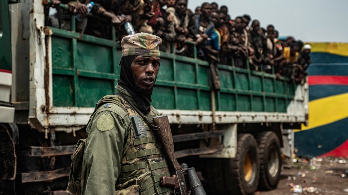 An M23 fighter in front of a truck with detained Congolese soldiers.