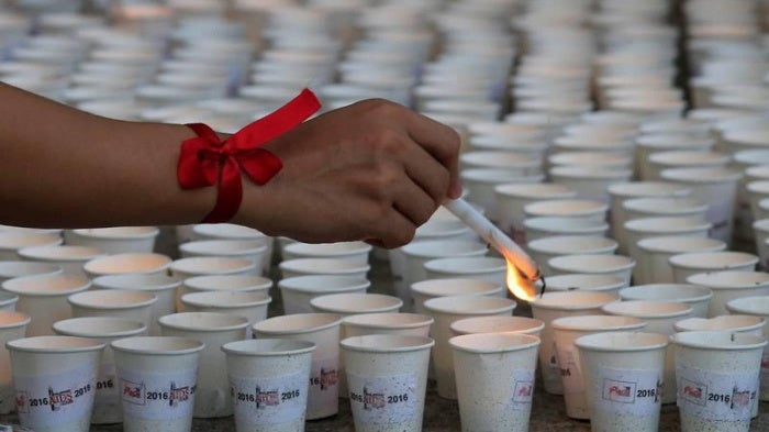 A supporter lights candles in commemoration of HIV/AIDS victims in the Philippines at a ceremony in Quezon City, Metro Manila, May 14, 2016. 