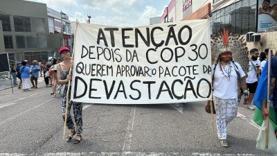Activists carry a banner warning of efforts to dismantle environmental licensing requirements in Brazil.