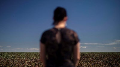 Carina, a women in her mid-30s who studies at a school in the municipality of Primavera do Leste, Mato Grosso, stands near a cotton plantation. Carina suffered acute poisoning while attending school in 2017: “I started feeling sick, nauseous…. I started v