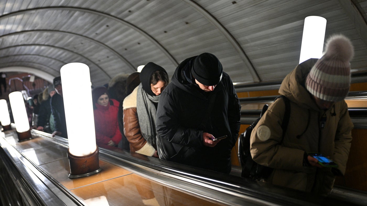People use their smartphones while riding an escalator in the Moscow metro, Russia, on February 12, 2026.