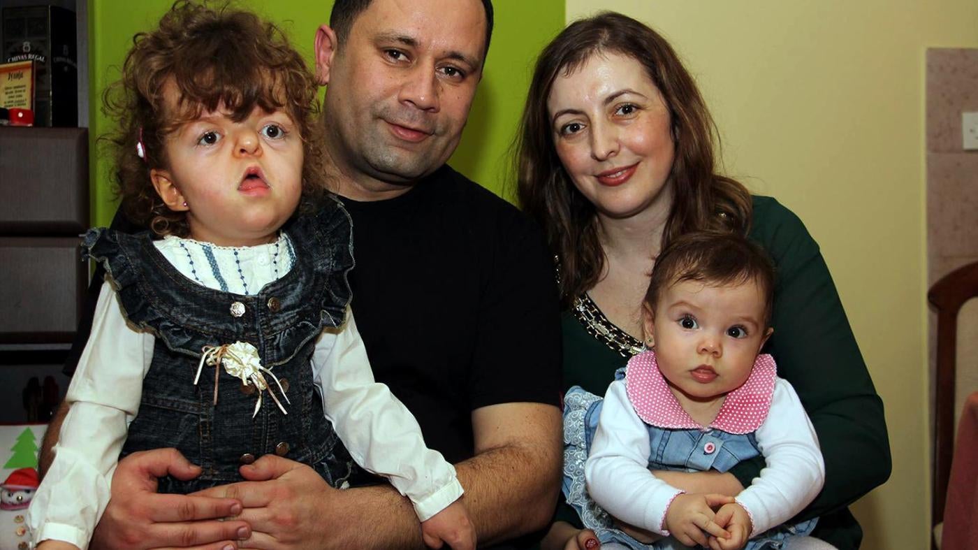 Julija Čuković, who spent ten months of her life in an institution, at home in Kragujevac with her parents, where she enjoys to play with her younger sister, also in the photo. © 2016 Zoran Stamenković