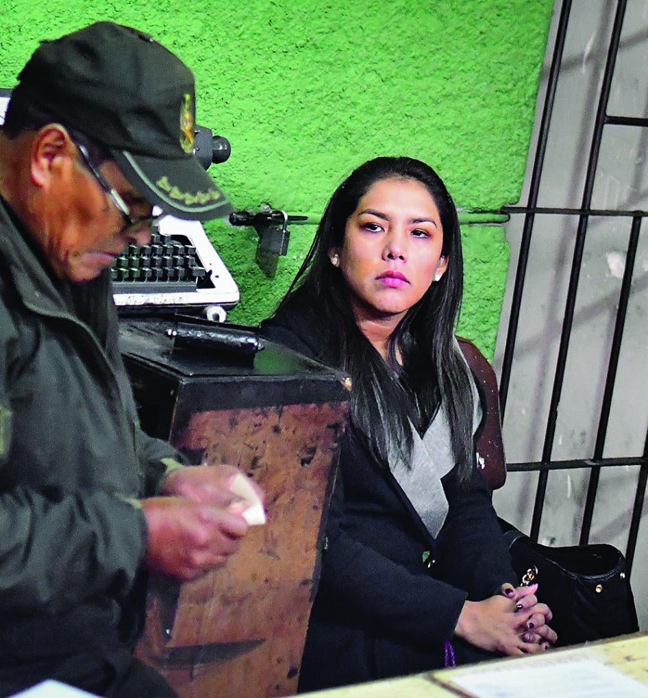A woman sits in a police station