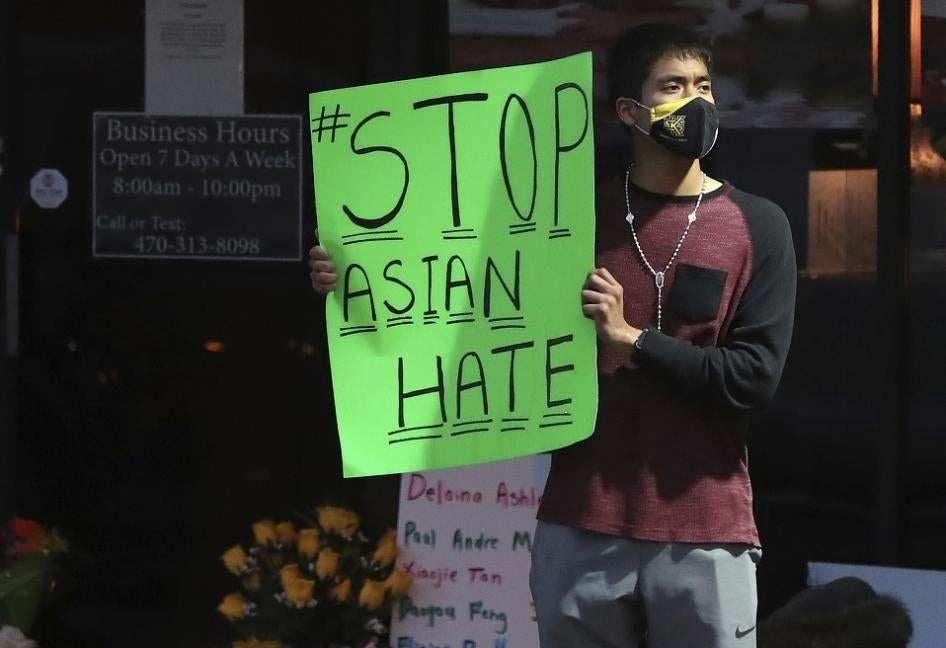 A man holds a sign reading “#StopAsianHate” outside Youngs Asian Massage in Acworth, Georgia on March 17, 2021, where four people were fatally shot the day before. 