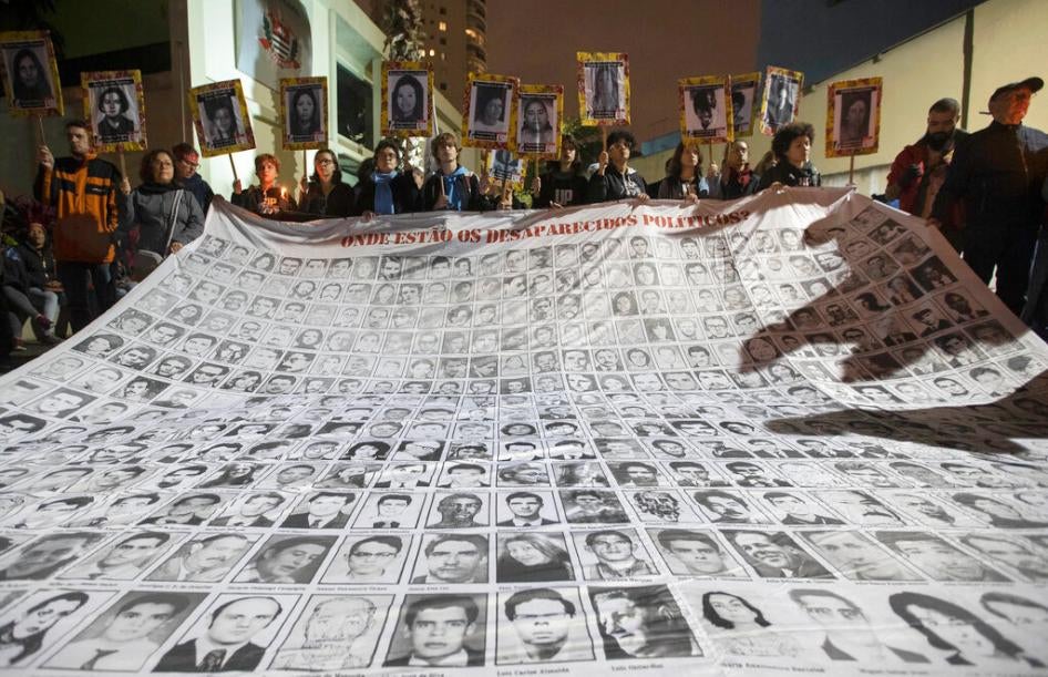 Demonstrators show photos of people killed during Brazil's dictatorship outside a police station that used to be a torture center used by the dictatorship in Sao Paulo, Brazil on August 5th, 2019.