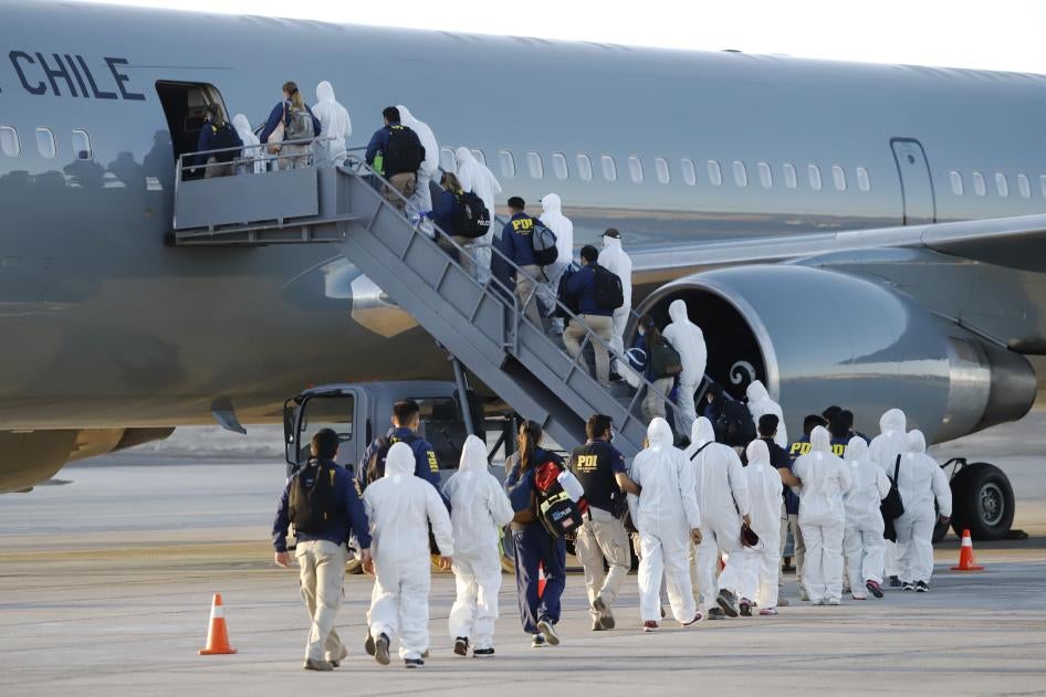 Venezuelan migrants board a plane as they are being deported from Chile, at the General Diego Aracena Aguilar International Airport in Iquique, Chile, on February 10, 2021. 