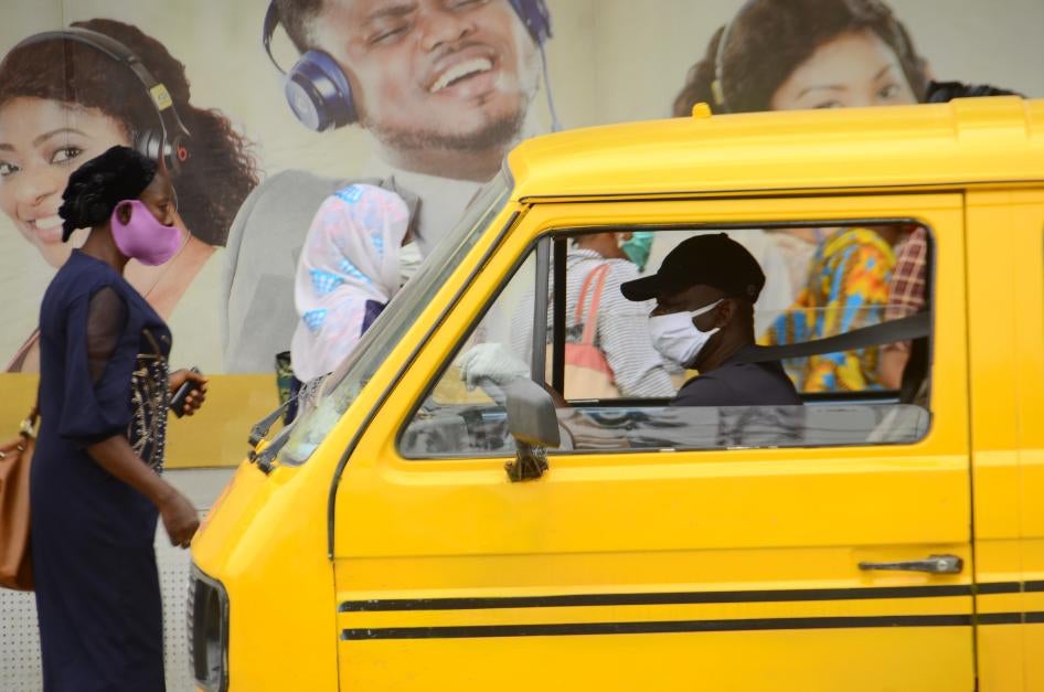 A yellow bus driver wearing a face mask