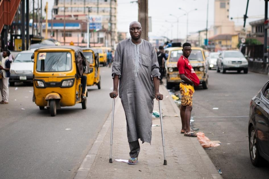 A man walking down a busy street with two canes