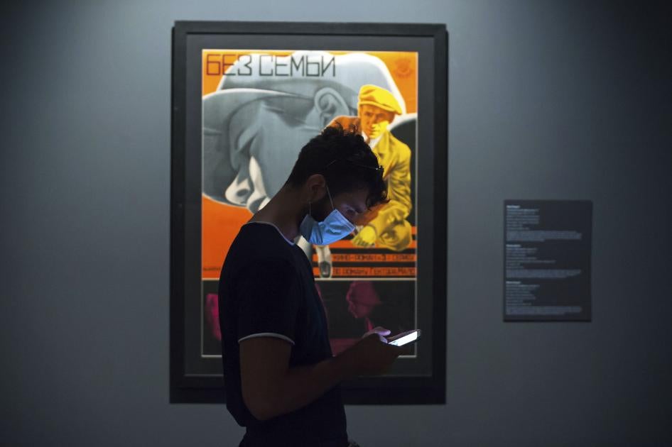 A young man wearing a face mask checks his mobile phone at the State Russian Museum, Saint Petersburg, May 26, 2020.