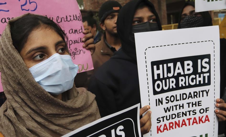 Women in masks holding up protest signs