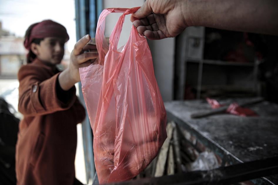 A boy is handed a bag of bread