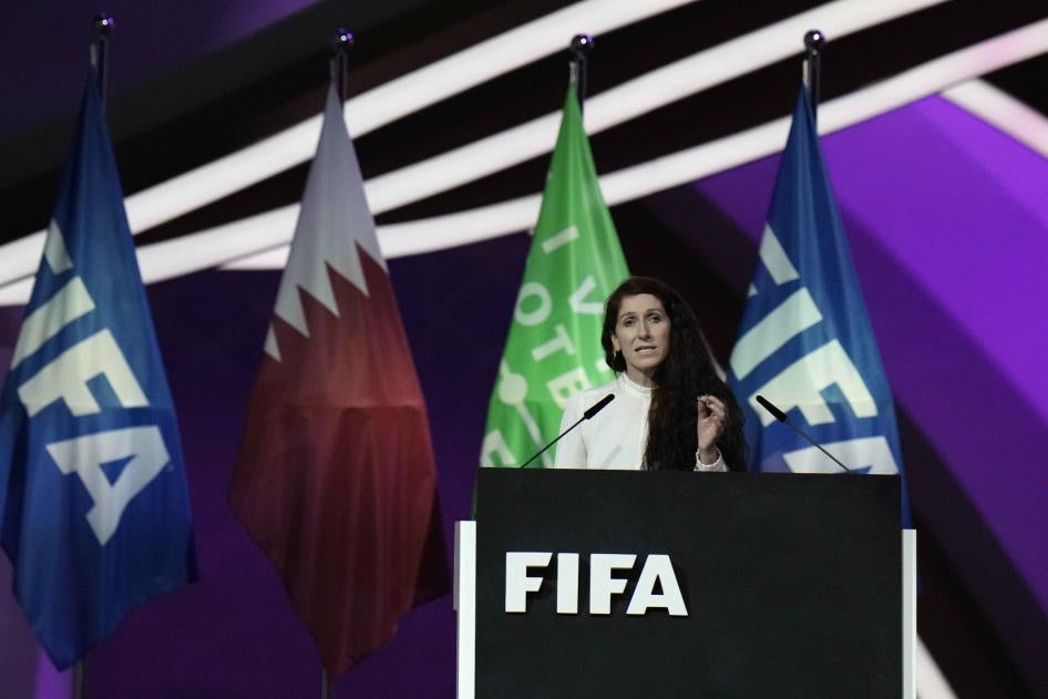 A woman speaks at a podium labeled "FIFA"