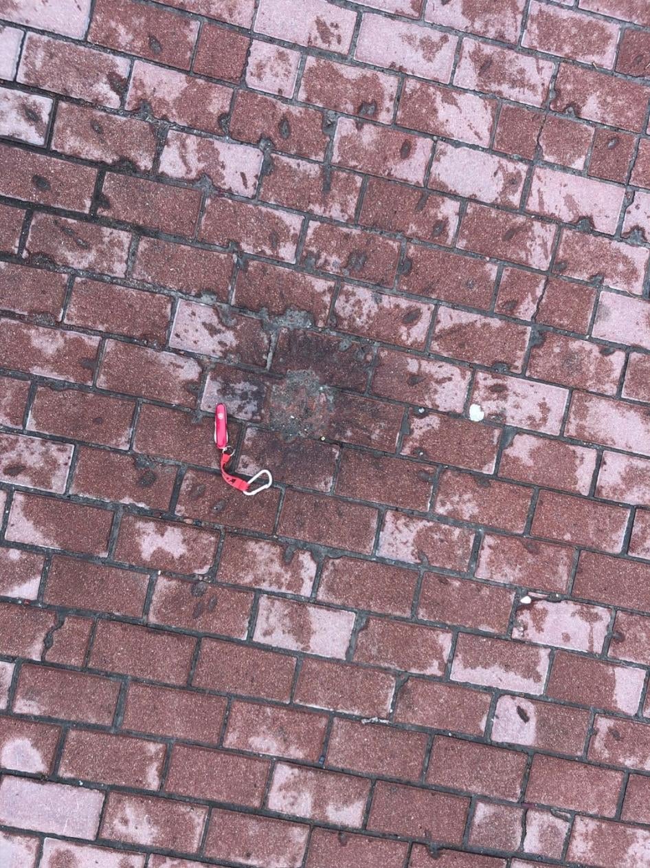 Следы от разлетающихся осколков на мостовой возле Черниговской областной детской больницы, оставшиеся после удара, который российские войска нанесли 17 марта 2022 г. Именно такие следы обычно остаются при подрыве фугасно-осколочного суббоеприпаса 9Н235.  Фото сделано 19 апреля 2022 г. 