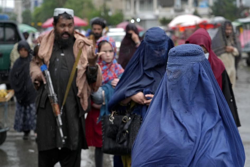 Afghan women walking by Taliban security forces in Kabul
