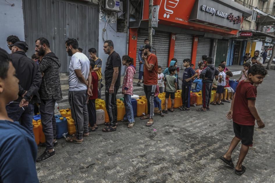 Palestinians stand in line to get water in the city of Rafah in the southern Gaza Strip amid ongoing hostilities between Israeli forces and Palestinian armed groups, November 13, 2023. 