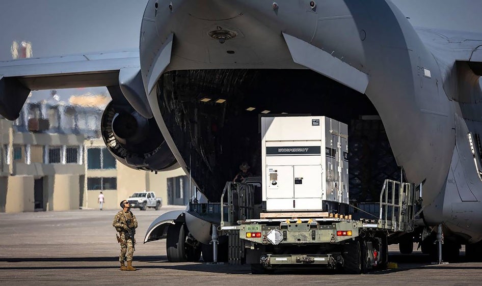 Auf der Rollbahn des internationalen Flughafens Toussaint Louverture in Port-au-Prince, Haiti, werden Hilfsgüter aus einem C-17-Frachtflugzeug der US Air Force ausgeladen. Das Flugzeug hatte Vorräte für das Camp geladen, das für kenianische Polizeikräfte gebaut wird, die eine multinationale Sicherheitsunterstützungsmission in Haiti leiten werden, 15. Mai 2024. 