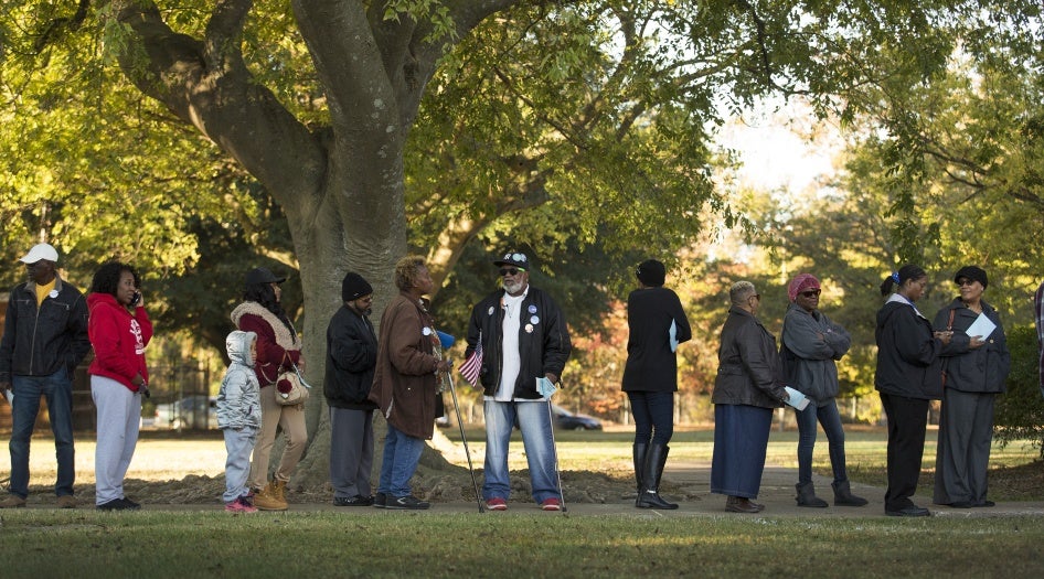 Bernard Smith Jr., 78 ans (centre de la photo) faisait la queue avec d'autres citoyens américains à Norfolk, en Virginie, pour voter lors de l’élection présidentielle tenue le 8 novembre 2016. Smith avait été précédemment privé du droit de vote en raison d’une condamnation antérieure pour un crime, mais ce droit a été rétabli dans son cas, lui permettant de participer à ce vote. © 2016 Bill Tiernan/The Virginian-Pilot via AP