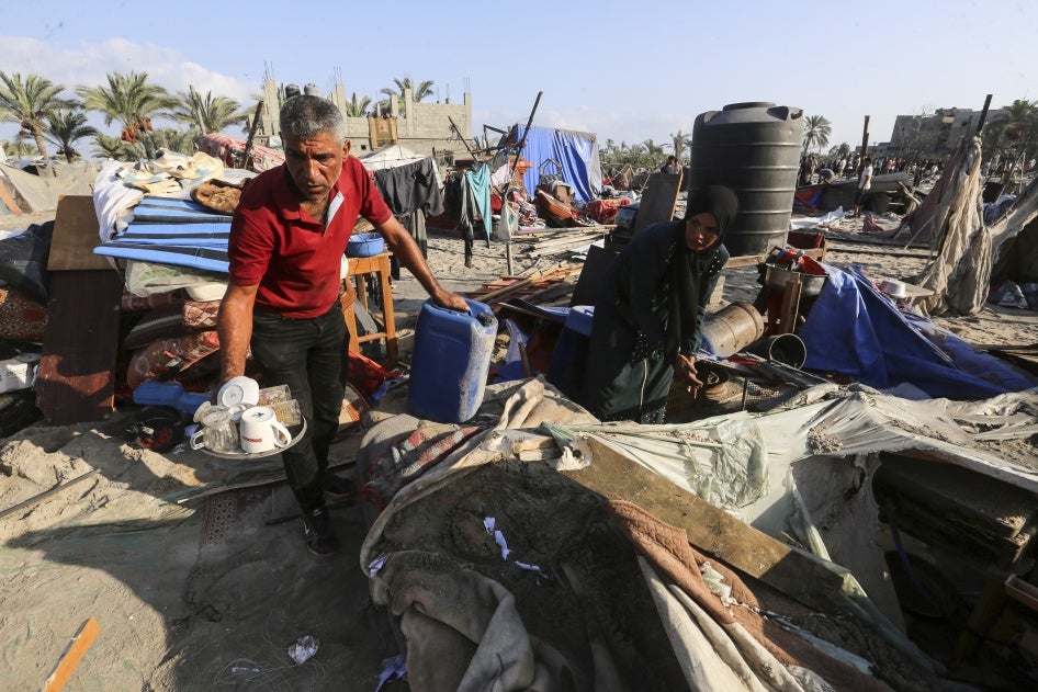 Palestinians inspect the site following Israeli strikes on a tent camp 