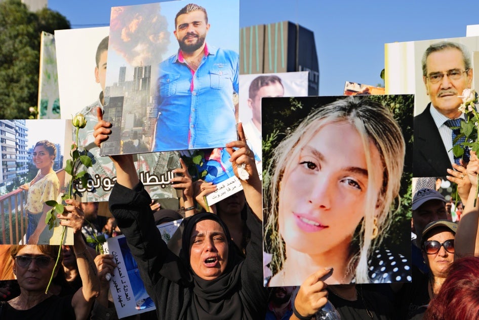 Relatives of victims of the deadly 2020 Beirut port explosion hold portraits of loved ones to mark the third anniversary of the blast, outside the port of Beirut, Lebanon, August 4, 2023. 