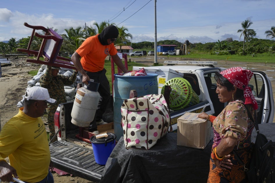 Civil protection officials, left, load a family's belongings on a truck to move from the island of Gardi Sugdub, located off Panama's Caribbean coast, to Nuevo Carti on the mainland, June 5, 2024.