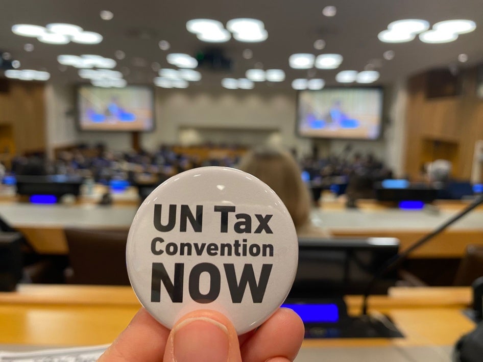 An activist holds up a button as negotiations for the tax convention take place at the United Nations in New York, February 6, 2025. 