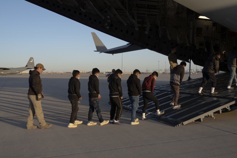 US Customs and Border Protection security agents guide people onboard a C-17 Globemaster III for a removal flight at Fort Bliss, Texas, January 23, 2025. 