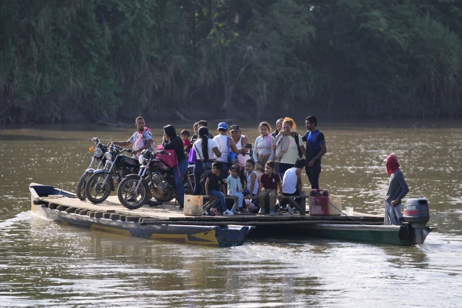 People cross a river to Venezuela from Tibu, Colombia on January 21, 2025, following fightings that killed dozens and forced thousands to flee their homes in the Colombian Catatumbo region.